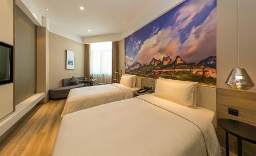 重庆重庆洪崖洞江景亚朵酒店的两张位于酒店客房的床,墙上挂着一幅画