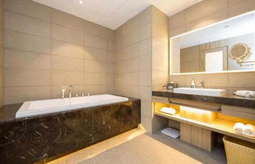重庆重庆洪崖洞江景亚朵酒店的带浴缸、水槽和镜子的浴室