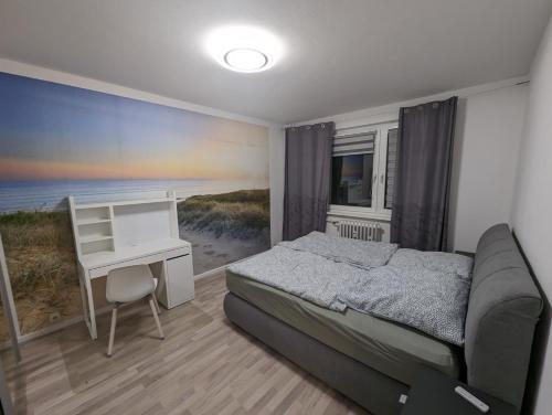 新勃兰登堡NB Vogelviertel zwei Zimmer Wohnung的一间卧室配有一张床和一张书桌,享有海滩美景