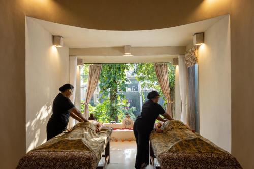 乌布Wapa di Ume Ubud的三个女人在窗户房间里做床