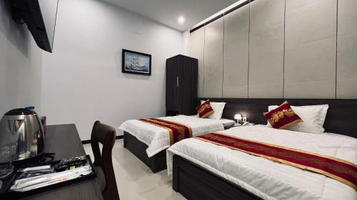 潘切Huy Hoàng Hotel的酒店客房设有两张床和电视。