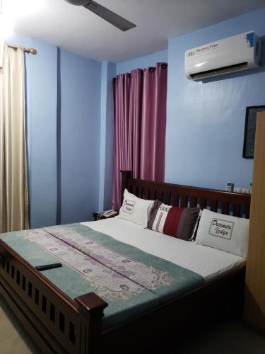 PrampramDreamers Lodge的一间卧室配有一张蓝色墙壁的床