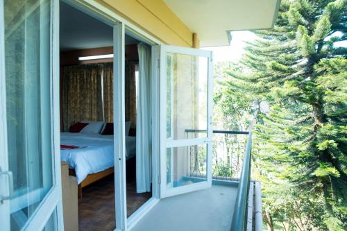 加德满都Holiday Home near Swayambhunath Stupa的玻璃门通向卧室,卧室配有床