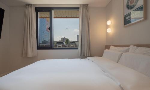 大田Annk Hotel Daejeon Daeheung的卧室设有一张白色大床和一扇窗户。