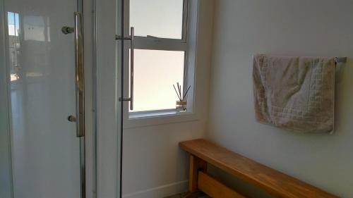 特卡波湖Lake Tekapo Double Room shared facilities的带淋浴的浴室和窗户上的毛巾