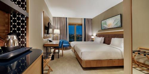 伊斯坦布尔伊斯坦布尔图兹拉希尔顿逸林酒店的配有一张床和一张书桌的酒店客房