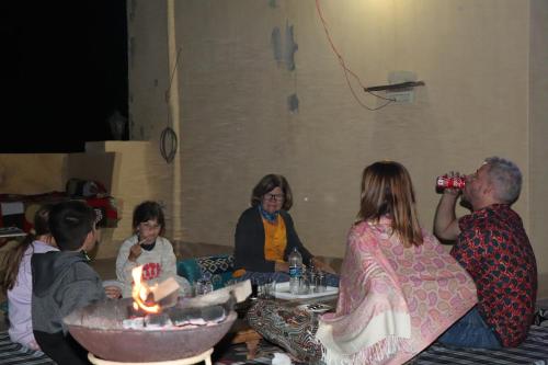 斋沙默尔Urmila Homestay的一群人坐在桌子旁,拿着蜡烛