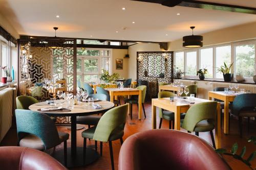 Thury-HarcourtLogis Hotel Le Relais De La Poste Restaurant Le Fil du Temps的餐厅设有桌椅和窗户。