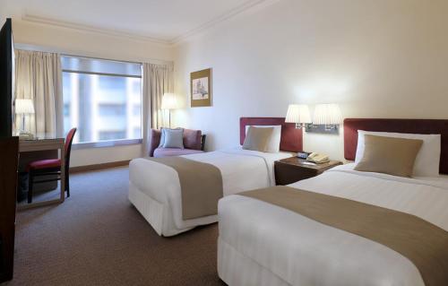 香港恒丰酒店的酒店客房配有两张床和一张书桌