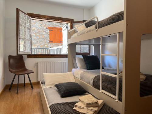卡尼略Cases de Canillo-Casa Sant Serni的带两张双层床和椅子的房间