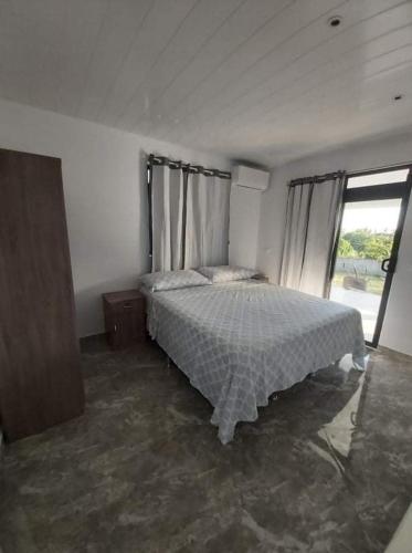 TeahupooVaimiti Lodge的一间卧室设有一张床和一个大窗户