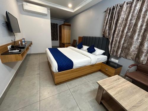 卡努尔KKM Highlands的一间酒店客房,配有一张床和一台电视