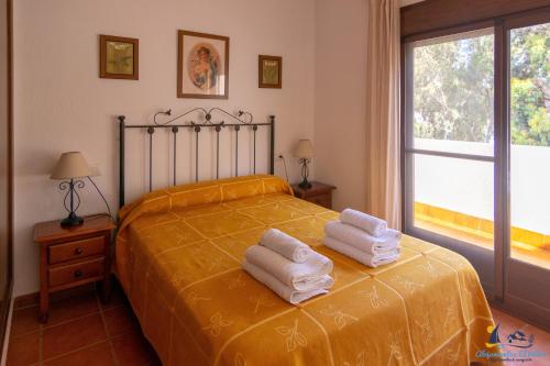 圣何塞El Velero Sotillo con Piscina的一间卧室配有带毛巾的床