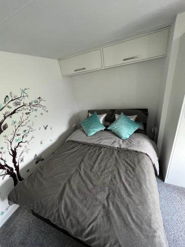 BarmstonThe Vale @Barmston的一间卧室配有一张带两个蓝色枕头的床