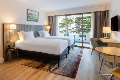 戛纳曼特浓俱乐部酒店的酒店客房设有一张床和一个阳台。