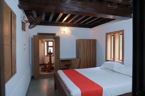 IrittiBest Heritage Home的一间卧室配有一张带红白毯子的床