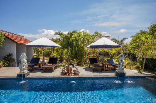 蓝梦岛Bagus Dream Beach Villa Lembongan的房屋旁的游泳池配有椅子和遮阳伞