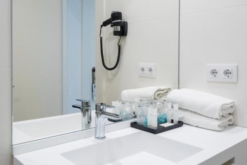 塔拉戈纳劳里亚酒店的一间带水槽和镜子的浴室