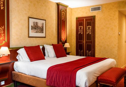 巴黎布玛尔查别墅酒店的一间卧室配有一张带红色枕头的大床