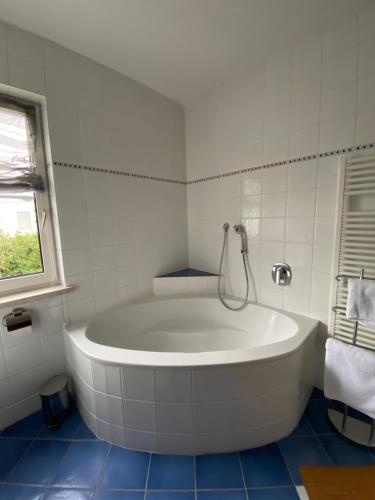 穆尔河畔布鲁克Haus Clearwater的白色瓷砖浴室内的白色浴缸