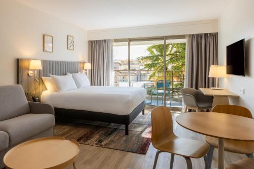 戛纳曼特浓俱乐部酒店的酒店客房设有一张床和一个阳台。