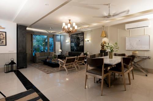 新德里R6 Luxury Peacefull & Comfortable的用餐室以及带桌椅的起居室。