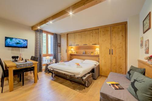 普拉吉拉托Studio Les Caribous Mountain Retreat - Happy Rentals的一间卧室配有一张床、一张桌子和一张桌子