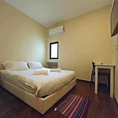 哥打京那巴鲁Treasure inn hotel的一间卧室配有一张床、一张桌子和一个窗户。