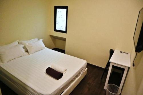 哥打京那巴鲁Treasure inn hotel的卧室配有白色的床和窗户。