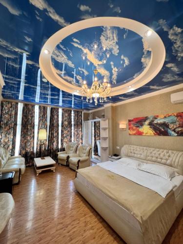 第比利斯Hotel Agava的一间卧室配有一张大床,天花板上装饰有绘画作品