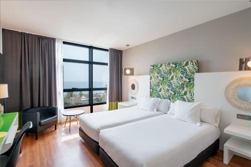 马拉加马拉加文奇酒店的酒店客房设有一张床和一个大窗户
