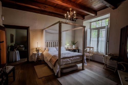 斯韦伦丹Moolmanshof 1798, Traditional Cape Dutch H-Shaped Farmhouse的一间卧室设有天蓬床和窗户。