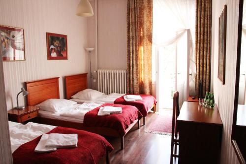索波特伊雷娜酒店的酒店客房,配有三张带红色床单的床