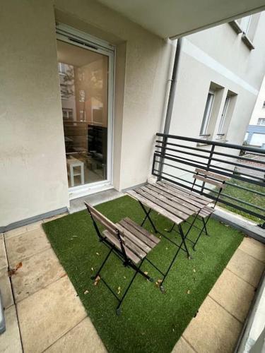 斯特拉斯堡Charmant T2 + parking et balcon的两把长椅坐在带草地的庭院里