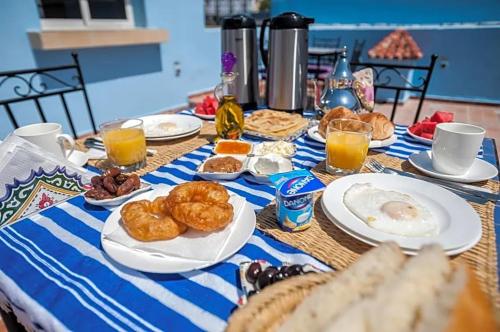 舍夫沙万阿苏尔普尔塔住宿加早餐旅馆的餐桌上摆放着早餐食品和橙汁盘