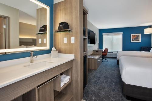 奇蒂豪克Holiday Inn Express Kitty Hawk - Outer Banks, an IHG Hotel的一间带水槽的浴室和一张位于客房内的床
