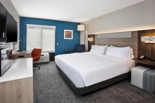 奇蒂豪克Holiday Inn Express Kitty Hawk - Outer Banks, an IHG Hotel的酒店客房设有一张大床和一台电视机。
