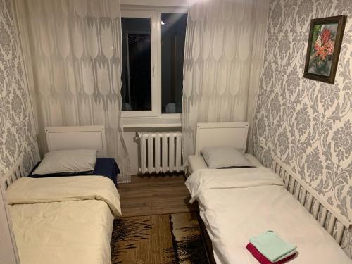 塔尔图Jalaka, Nice 2-bedroom apartment - 1 big bed - 2 single bed的带窗户的客房内设有两张单人床。