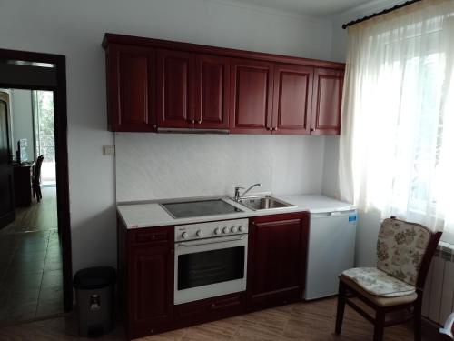 索非亚Цвят бяло的厨房配有木制橱柜、炉灶和水槽。