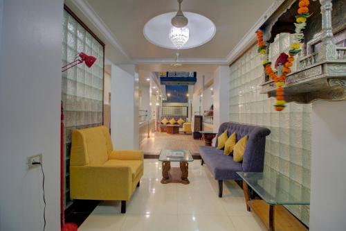 孟买OYO SilverKey Hotel Manas Residency的客厅配有两把椅子和一张桌子