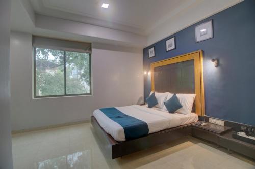 孟买OYO SilverKey Hotel Manas Residency的一间卧室设有一张大床和窗户