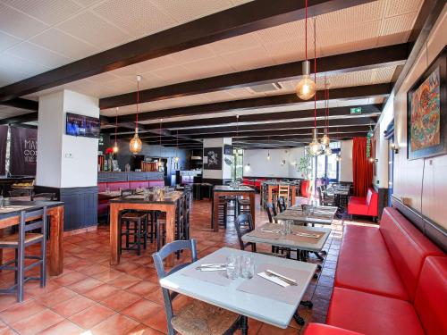 马赛马赛市中心圣查尔斯火车站宜必思酒店的一间带桌椅的餐厅和一间酒吧