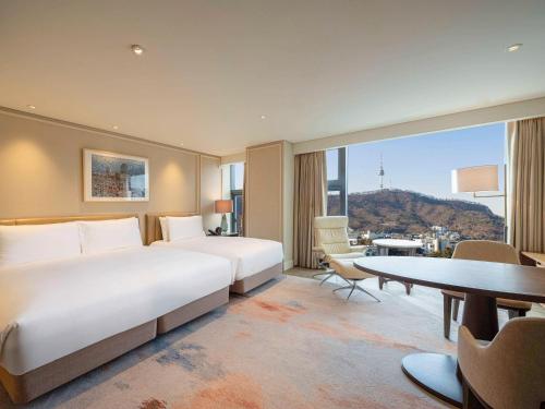 首尔首尔大使 - 铂尔曼酒店的酒店客房设有两张床和一张桌子。
