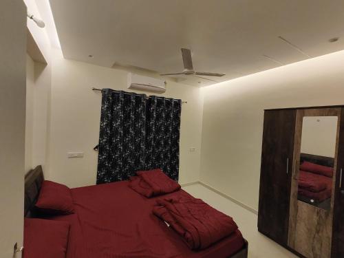 达曼Gandhi Villa的一间卧室设有红色的床和窗户。