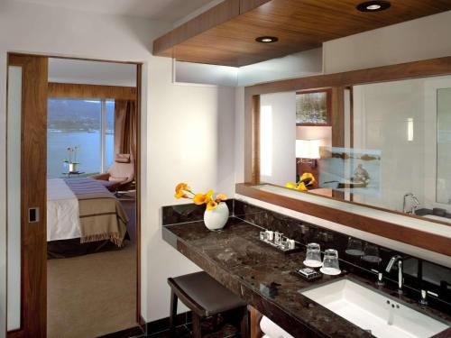 温哥华费尔蒙特环太平洋酒店的一间带水槽和镜子的浴室以及一张床