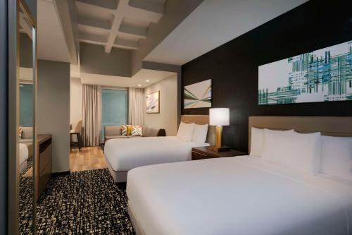 洛杉矶Hyatt House LAX Century Blvs的酒店客房设有两张床和一台平面电视。