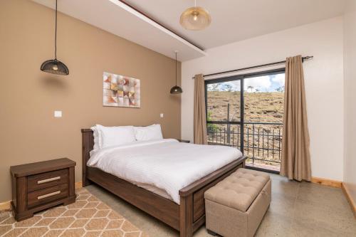 KajiadoTulia Villas, 3 and 4 bedroom Villas, Champagne Ridge的一间卧室设有一张床和一个大窗户