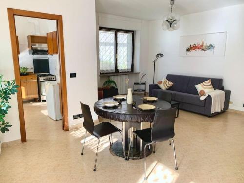 都灵Appartamento indipendente a Mirafiori Sud的客厅配有桌椅和沙发