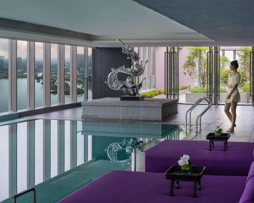 宁波宁波湖畔凯悦尚萃酒店的酒店大堂的 ⁇ 染,设有一个游泳池
