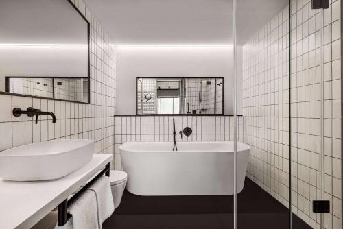 华沙Vienna House by Wyndham Mokotow Warsaw的白色的浴室设有浴缸和卫生间。